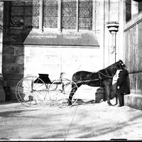 Voiture à cheval au pied d'une église